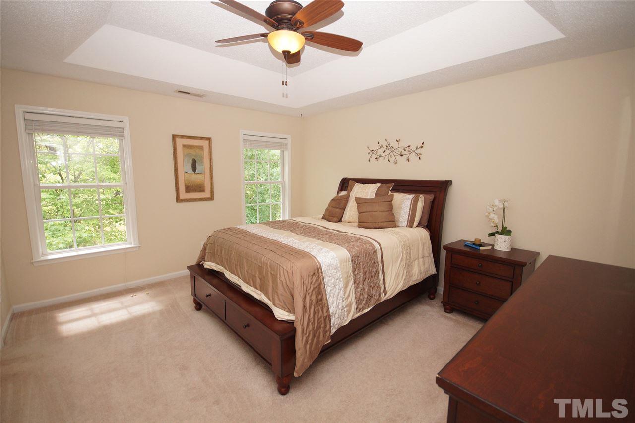9241 Shallcross Way Raleigh, NC 27617 - Photo 13 of 22 a spacious bedroom with a bed and a chandelier