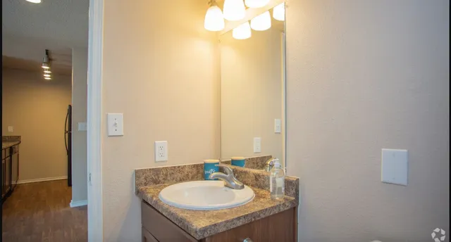 a view of swimming pool with lawn chairs and large trees