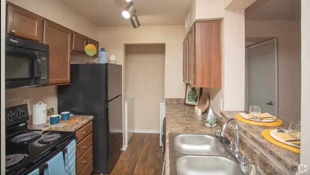 a kitchen with stainless steel appliances granite countertop a sink stove and refrigerator