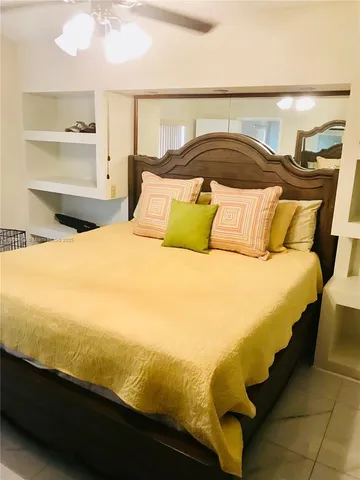 a large white bed in a bedroom next to a window