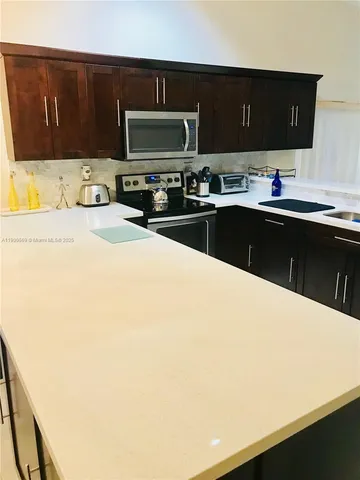 a kitchen with a sink a stove and cabinets