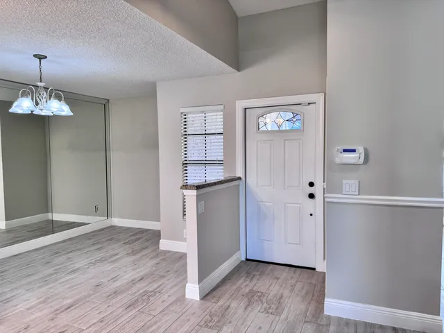 an empty room with wooden floor cabinet and windows