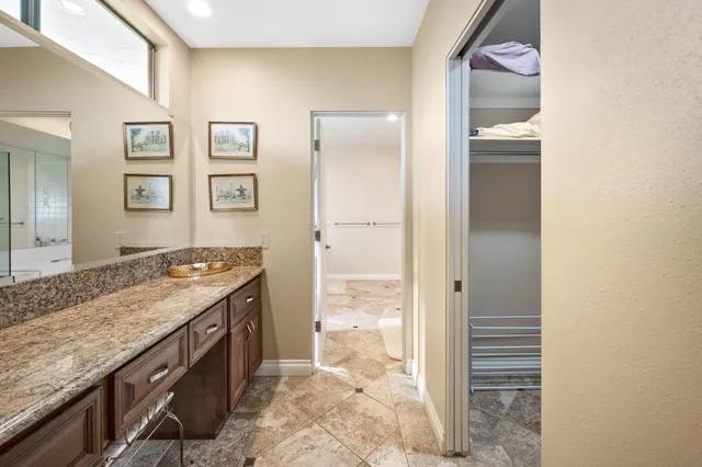 a bathroom with a granite countertop sink and a mirror