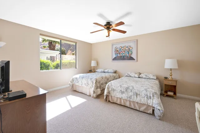 a bedroom with two beds and a window