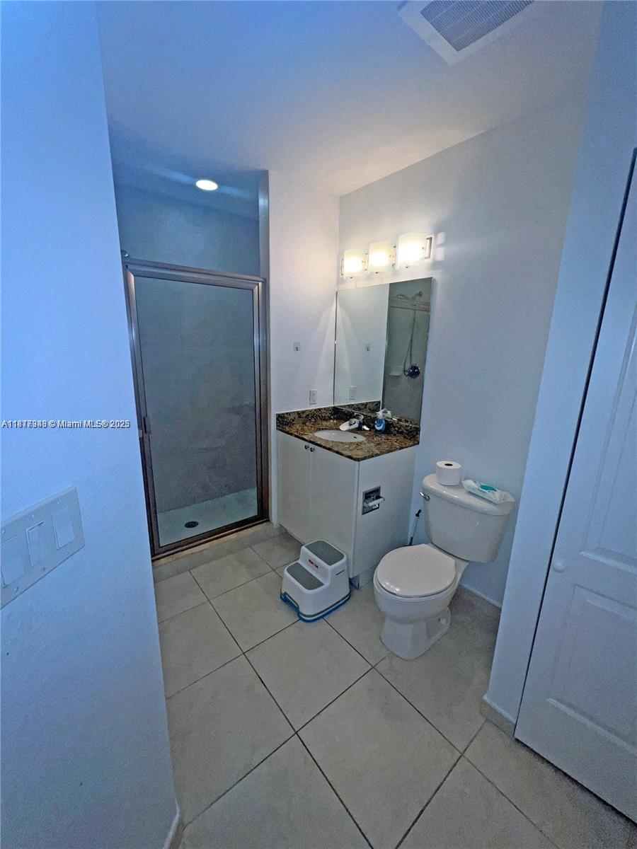 Royal Poinciana Hollywood, FL 33020 - Photo 21 of 26 a bathroom with a toilet a sink a mirror and shower