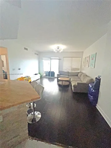 a living room with furniture kitchen view and a table