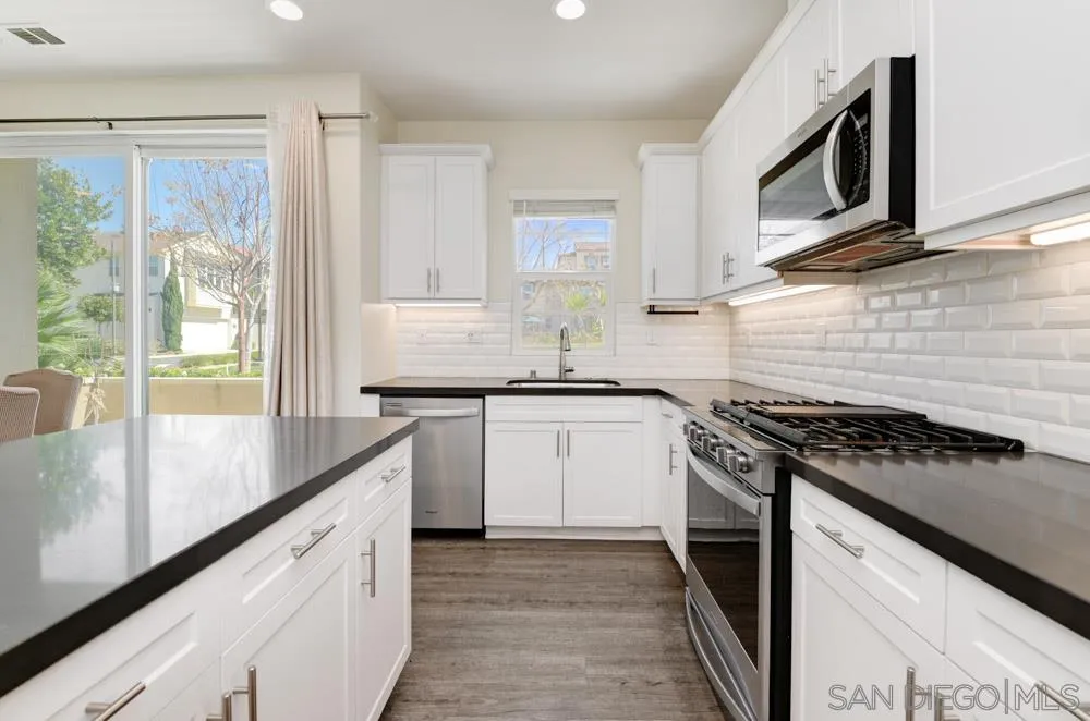 4314 Star Path Way, Unit 1 Oceanside, CA 92056 - Photo 2 of 40 a kitchen with granite countertop cabinets stainless steel appliances a sink and a window