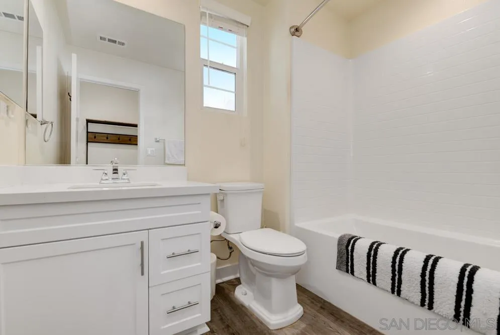 4314 Star Path Way, Unit 1 Oceanside, CA 92056 - Photo 25 of 40 a bathroom with a toilet a sink and a mirror