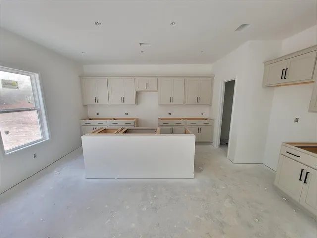 a view of kitchen with stainless steel appliances cabinets and a window