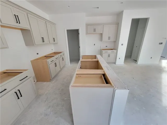a kitchen with white cabinets and white appliances