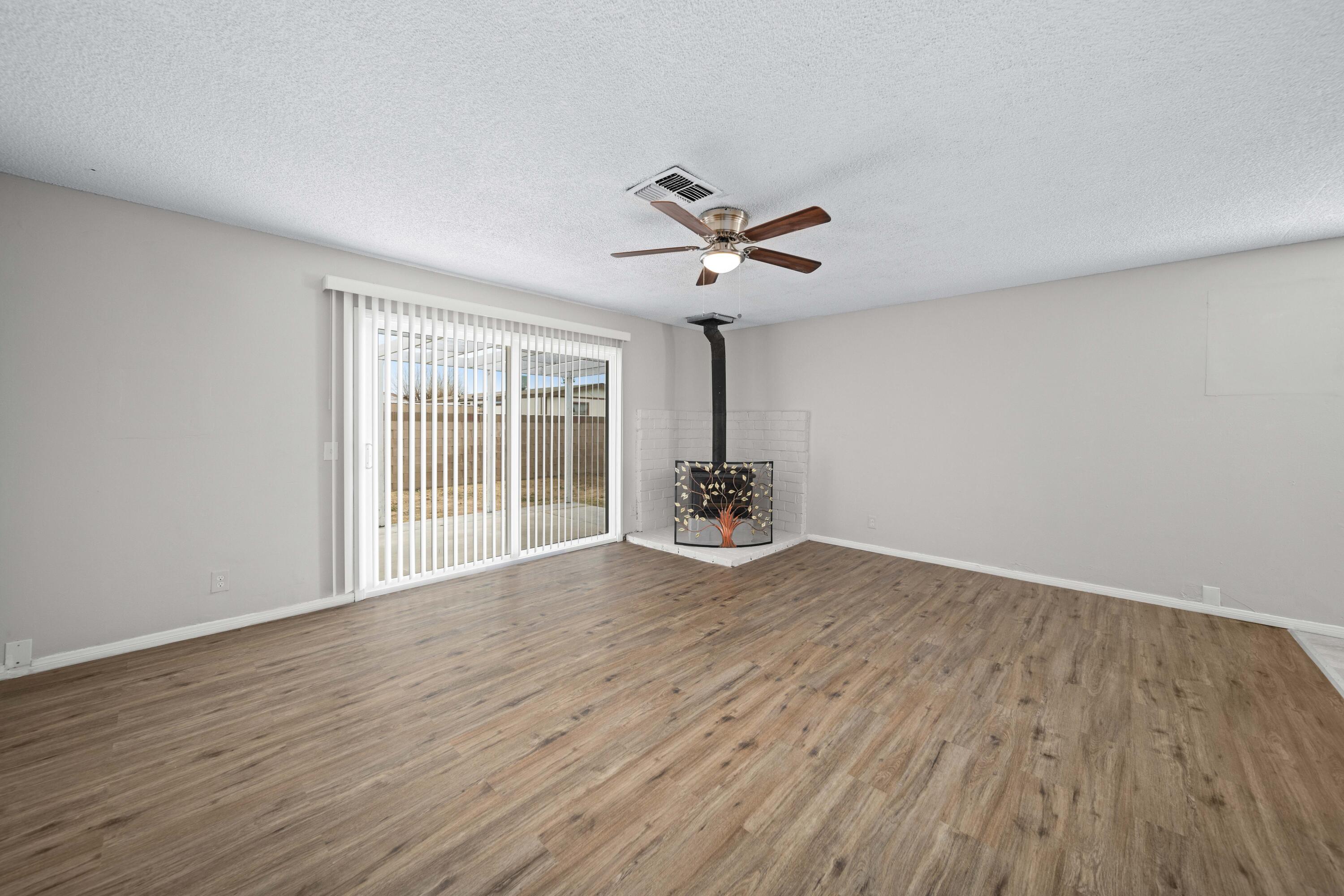 3360 West Roxbury Street Rosamond, CA 93560 - Photo 12 of 23 a view of an empty room with a window and wooden floor