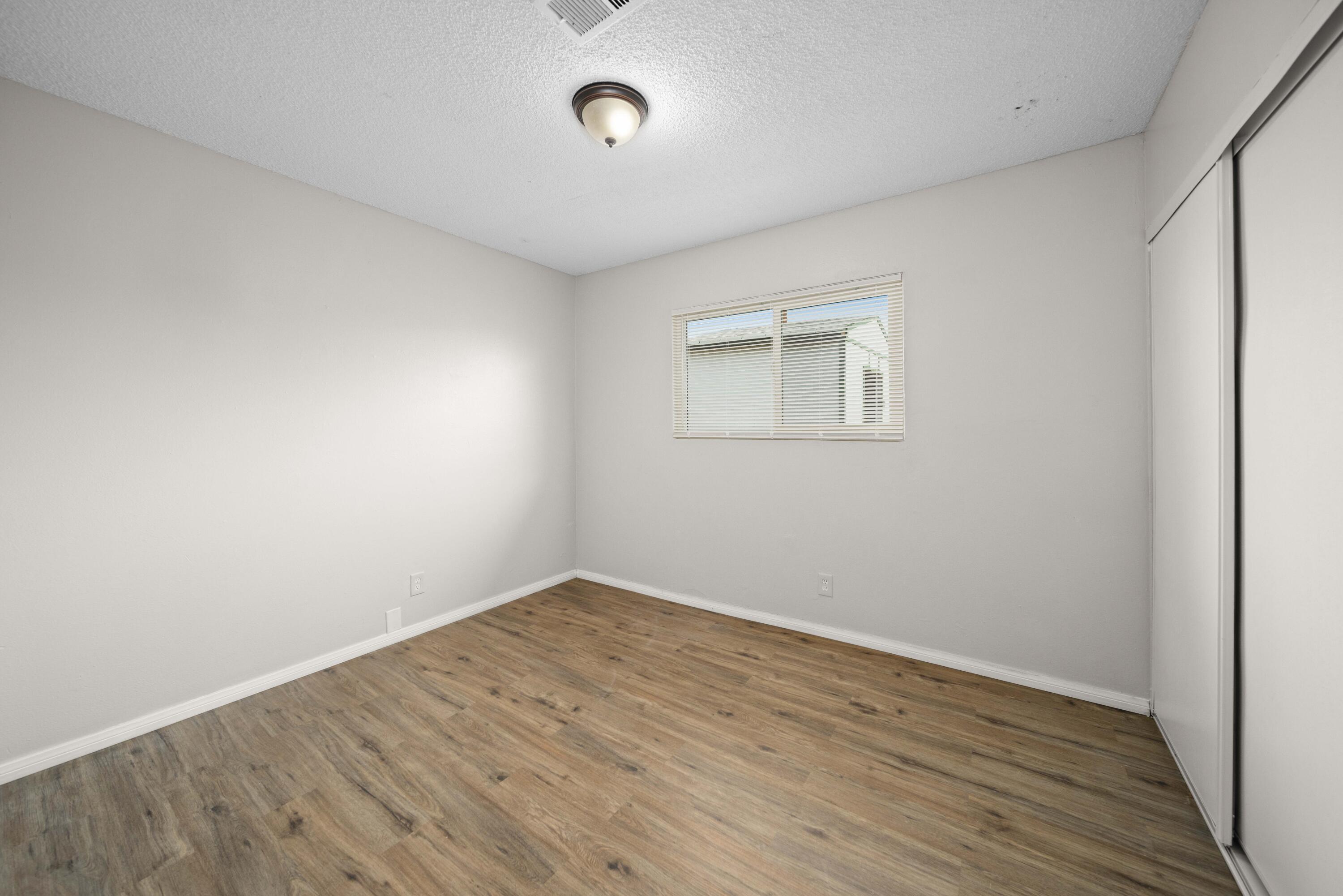 3360 West Roxbury Street Rosamond, CA 93560 - Photo 19 of 23 an empty room with wooden floor and windows