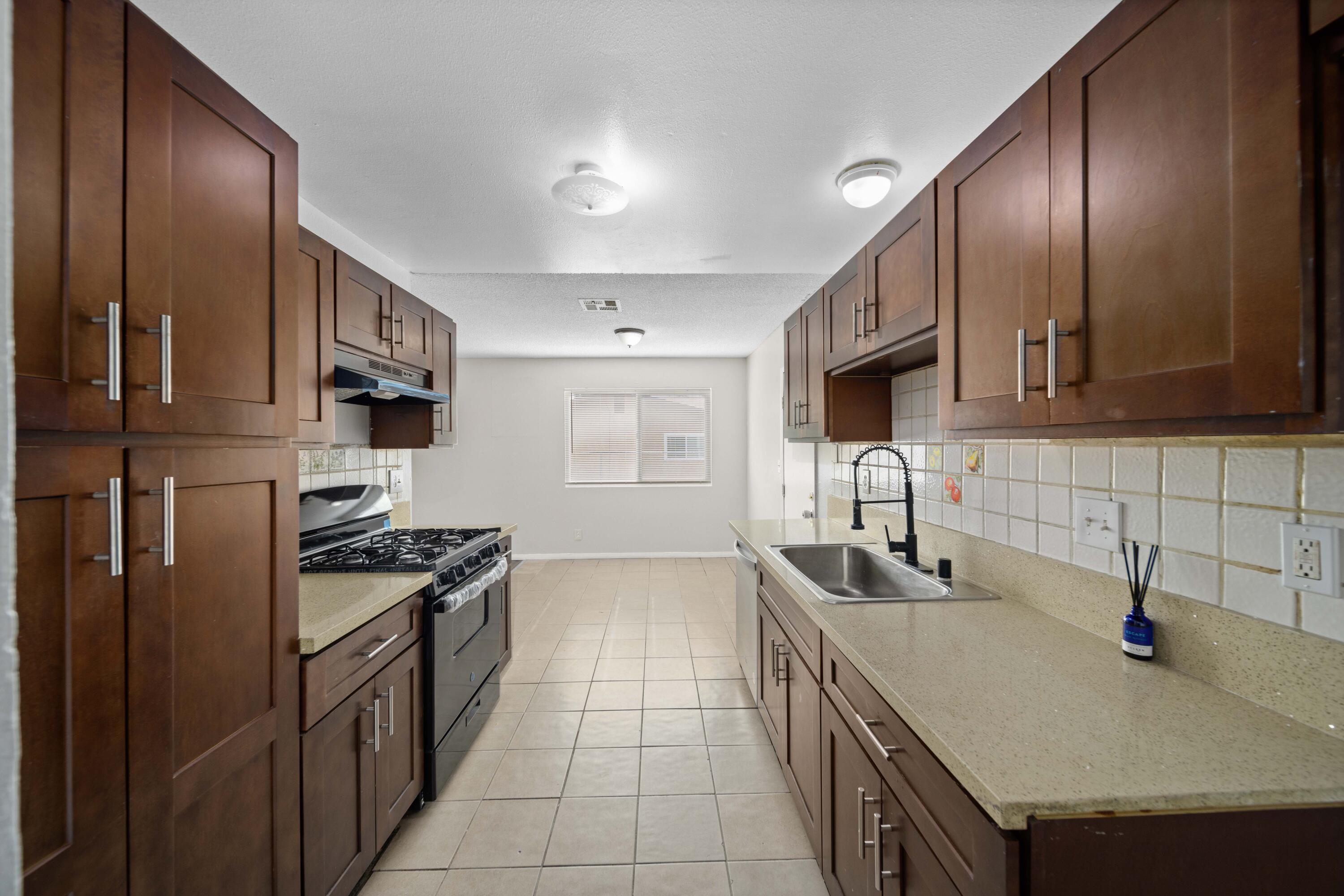 3360 West Roxbury Street Rosamond, CA 93560 - Photo 4 of 23 a kitchen with granite countertop stainless steel appliances a sink stove top oven and cabinets