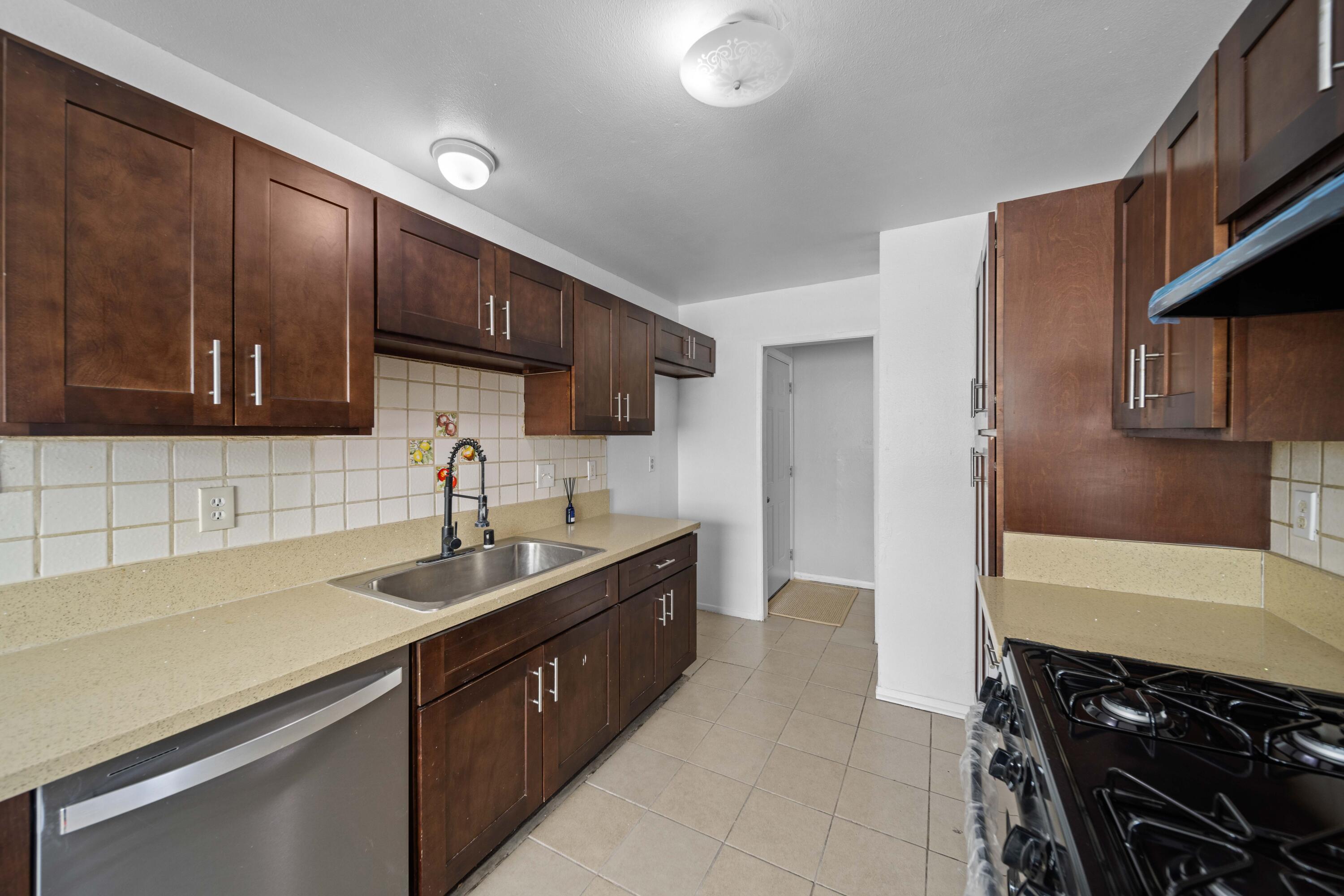 3360 West Roxbury Street Rosamond, CA 93560 - Photo 6 of 23 a kitchen with a sink stove top oven and cabinets
