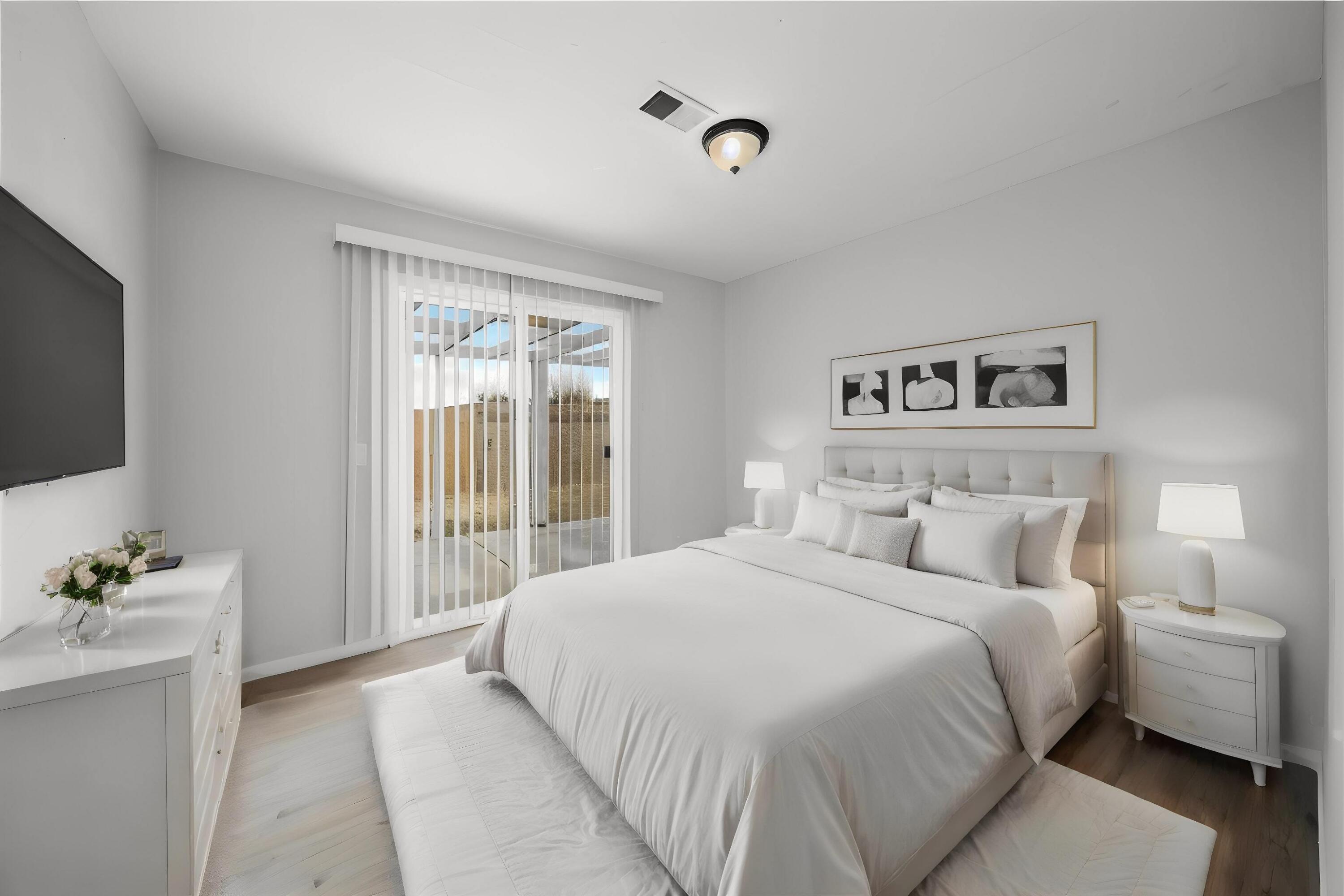 3360 West Roxbury Street Rosamond, CA 93560 - Photo 9 of 23 a bedroom with a balcony a bed and a flat screen tv
