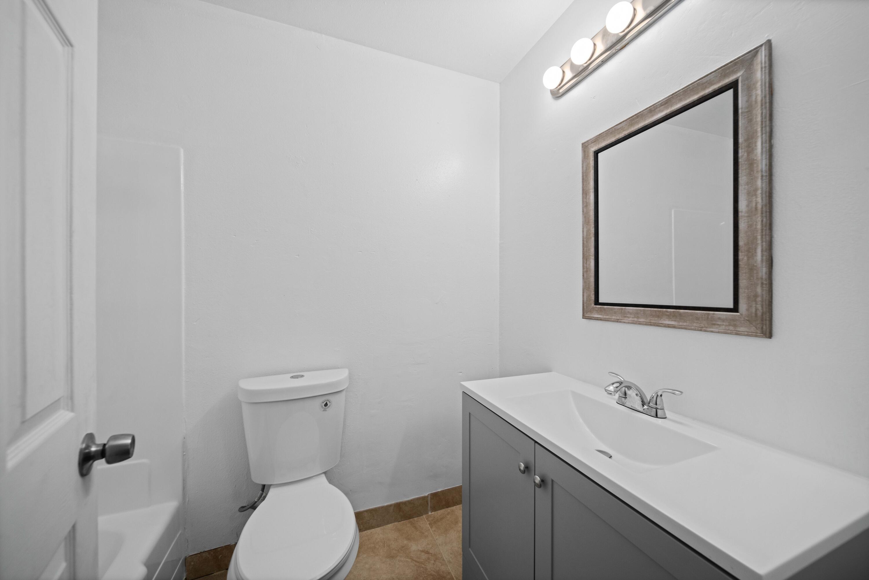 3360 West Roxbury Street Rosamond, CA 93560 - Photo 10 of 23 a bathroom with a toilet a sink and mirror