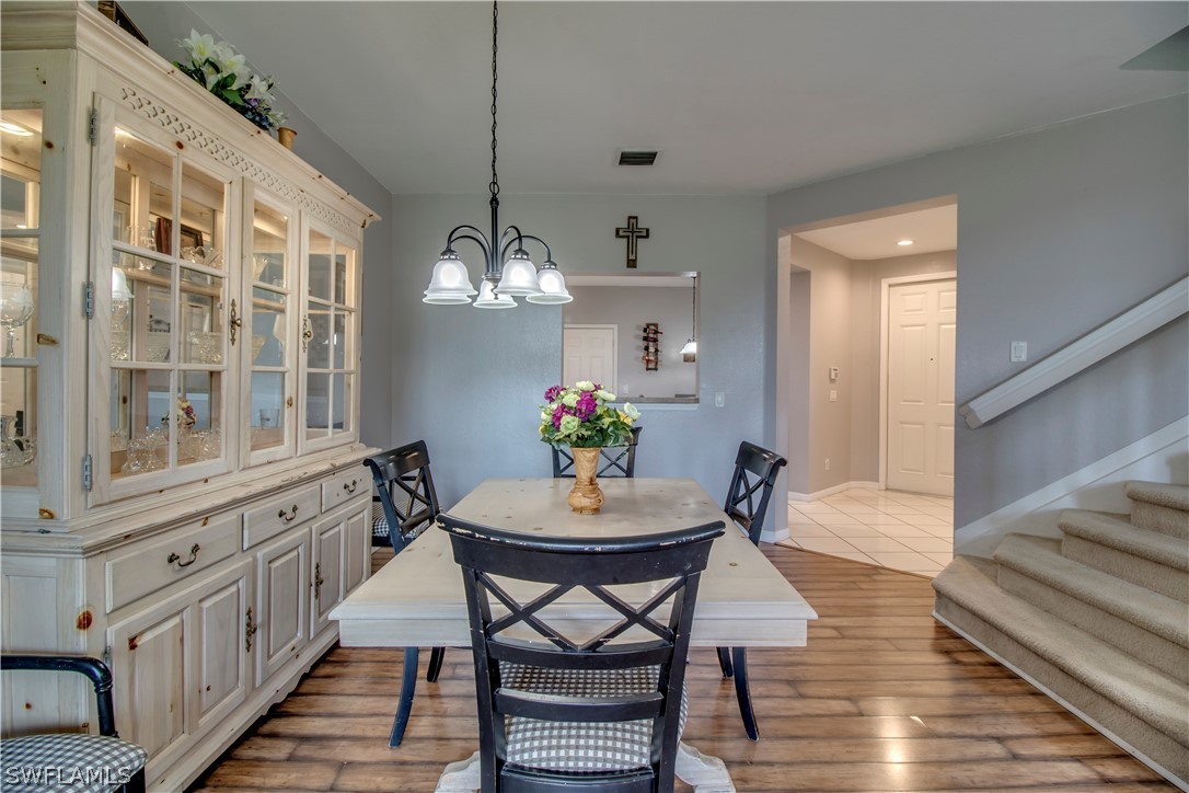4084 Cherrybrook Loop Fort Myers, FL 33966 - Photo 5 of 29 a view of a dining room with furniture wooden floor and a chandelier