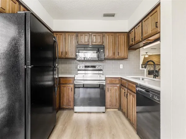a kitchen with stainless steel appliances granite countertop a stove microwave and cabinets
