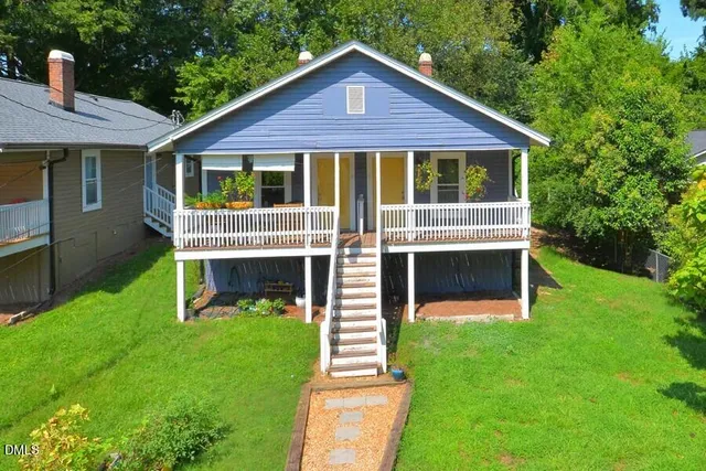 a front view of a house with a yard and garden