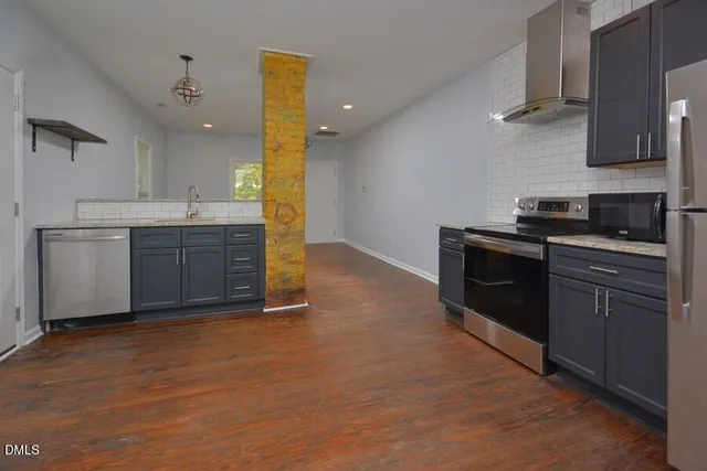 a kitchen with stainless steel appliances granite countertop a stove a sink and a refrigerator