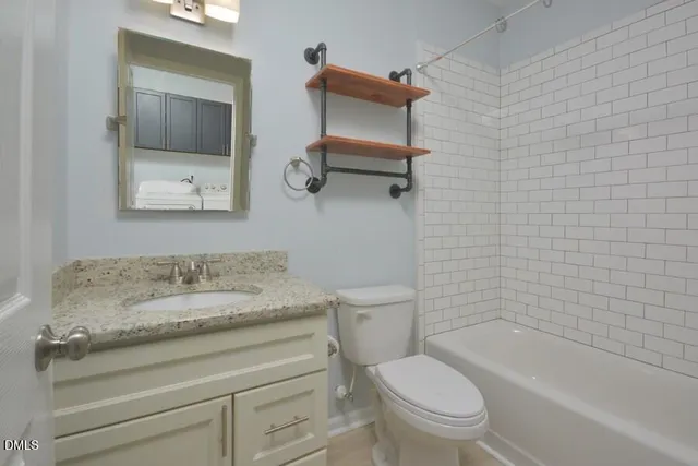 a bathroom with a granite countertop toilet a sink and bathtub