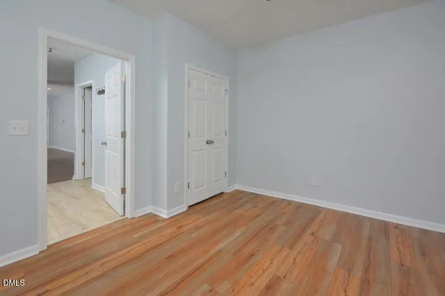 a view of a room with wooden floor and a bathroom