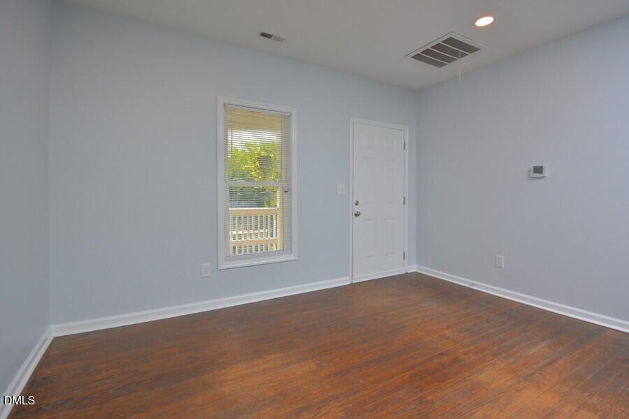 1030 Cornell Street, Unit B Durham, NC 27707 - Photo 4 of 22 a view of an empty room with wooden floor and a window