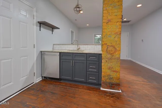 wooden floor in an empty room with a kitchen