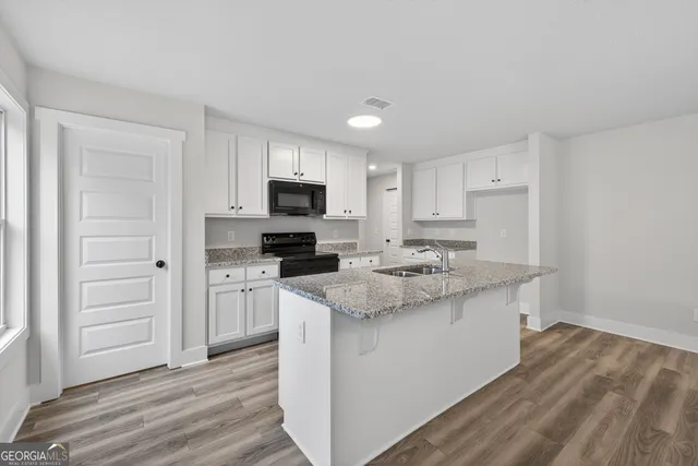 a kitchen with a sink a stove a microwave and cabinets