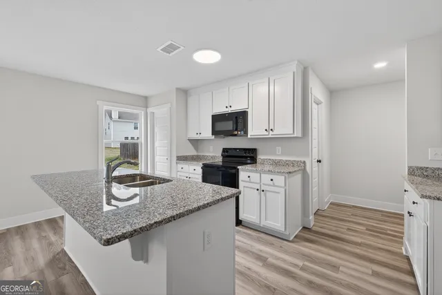 a kitchen with granite countertop a sink and cabinets