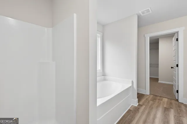 a bathroom with a granite countertop sink a bathtub and a mirror