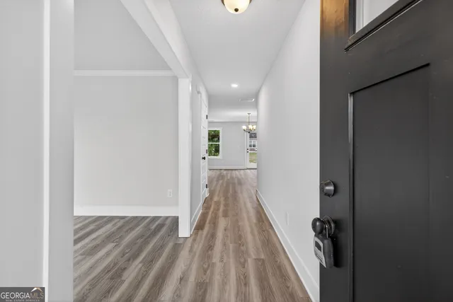 a view of a hallway with wooden floor and staircase