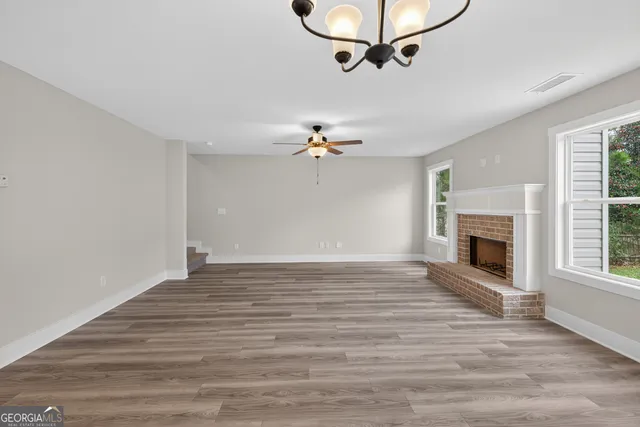 a view of a livingroom with a ceiling fan hardwood and a fireplace
