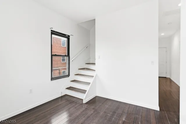 an empty room with wooden floor and window