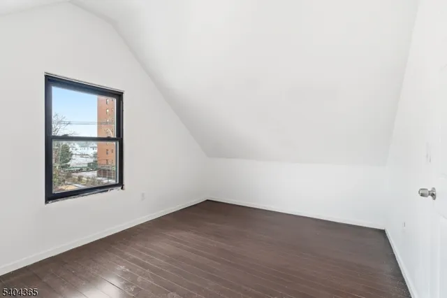 an empty room with wooden floor and white walls