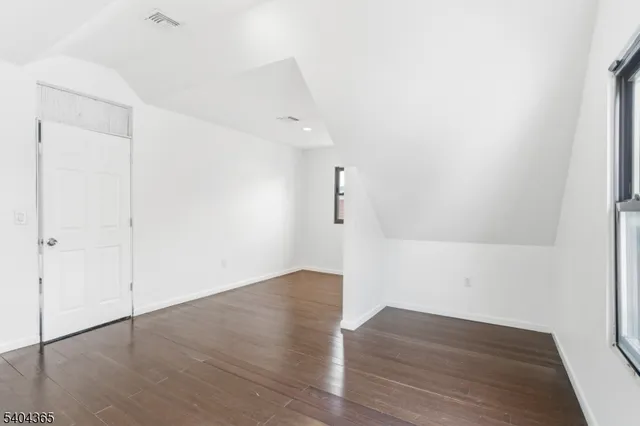an empty room with wooden floor and window