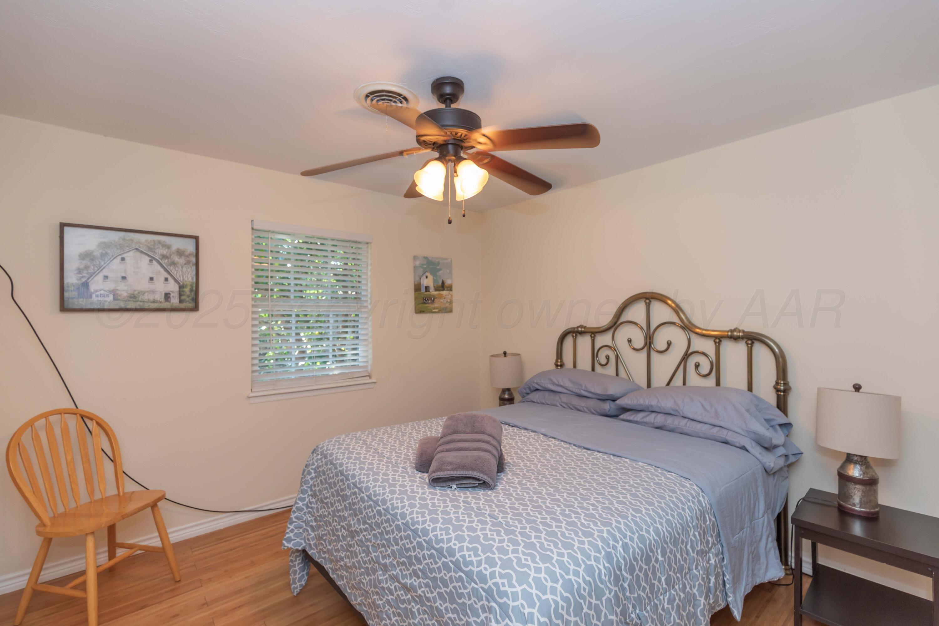 4427 Summit Circle Amarillo, TX 79109 - Photo 18 of 50 a bedroom with a bed and a chandelier