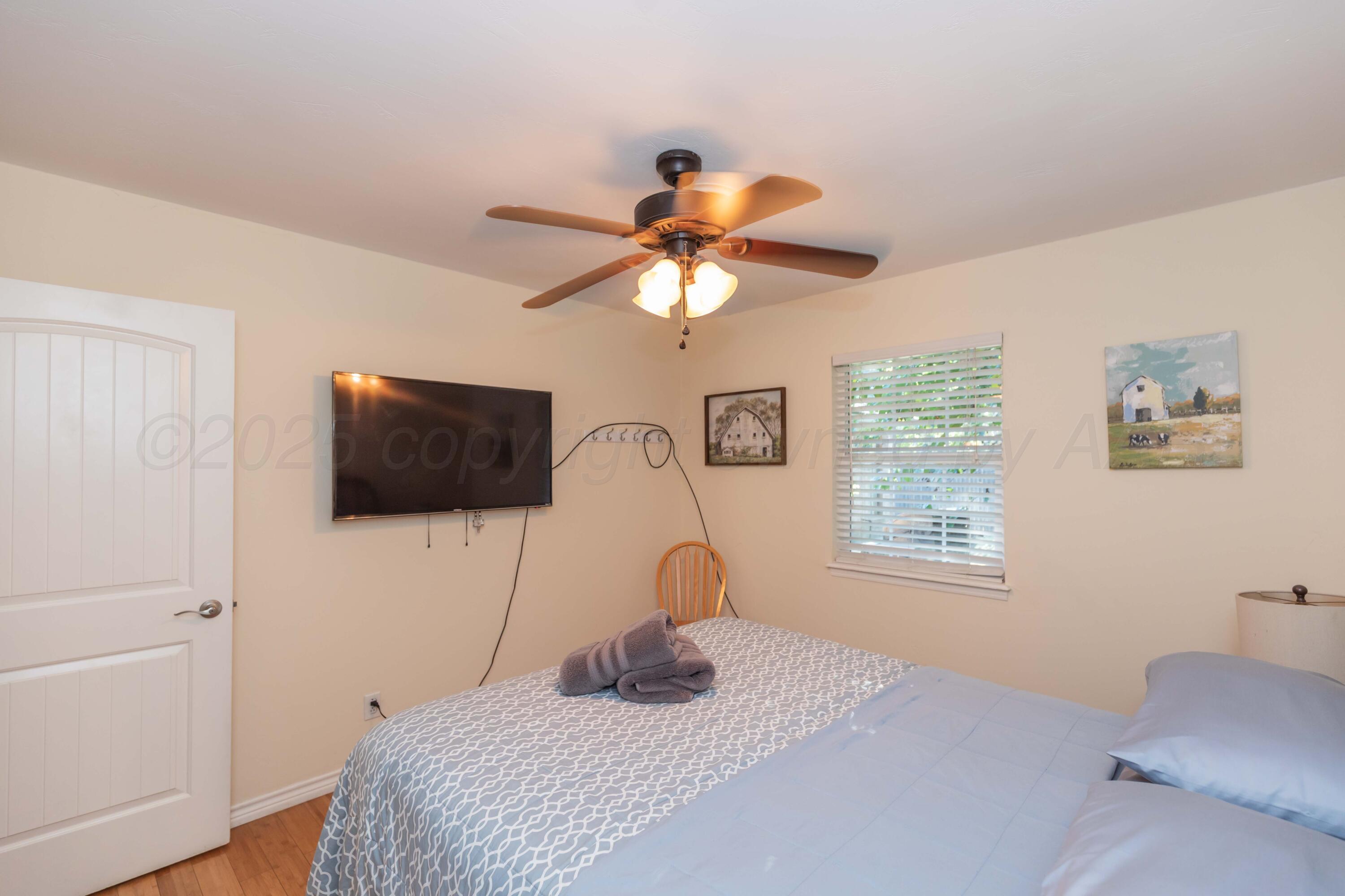 4427 Summit Circle Amarillo, TX 79109 - Photo 19 of 50 a bedroom with a bed and a flat screen tv