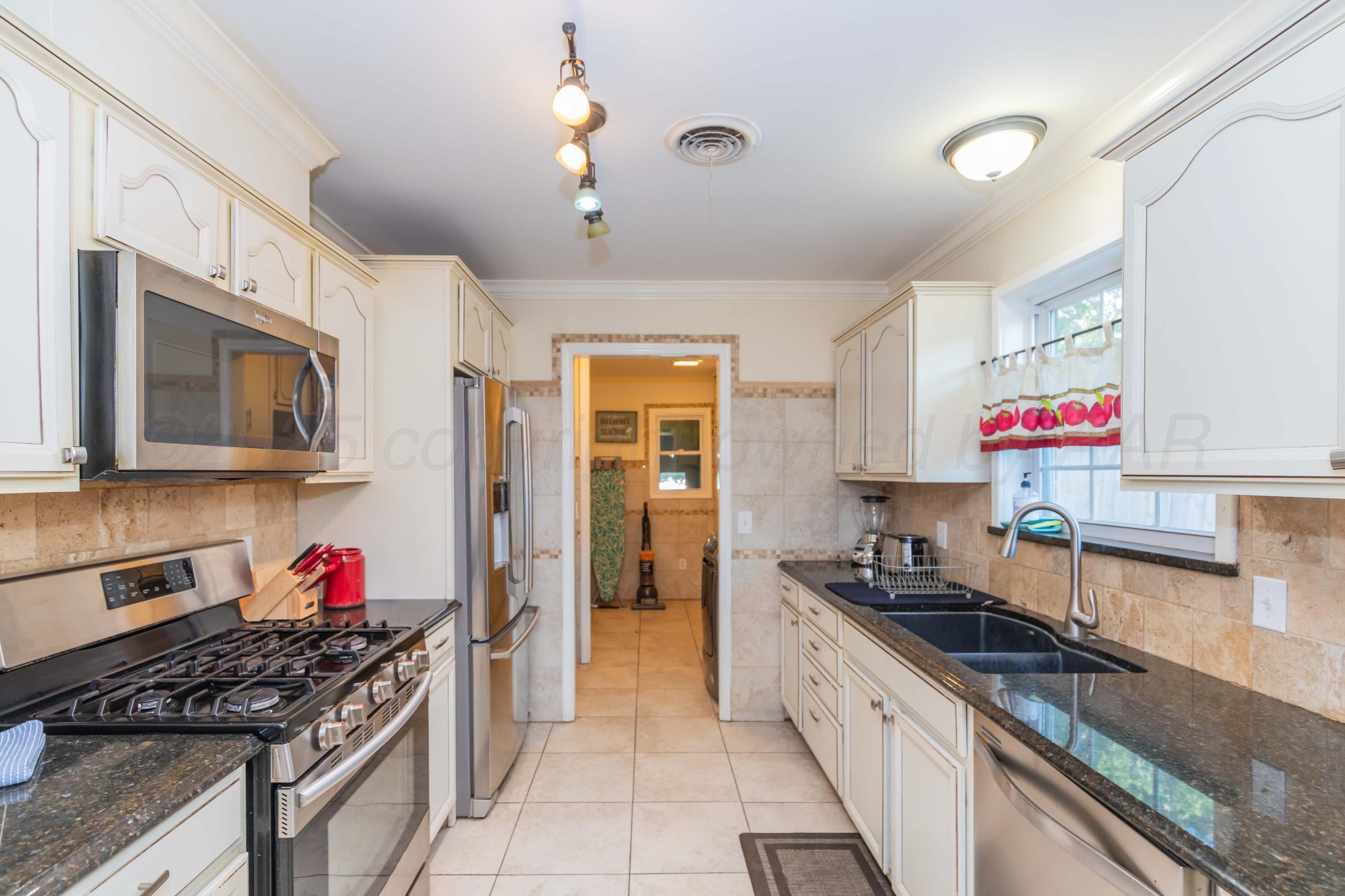 4427 Summit Circle Amarillo, TX 79109 - Photo 36 of 50 a kitchen with stainless steel appliances granite countertop a stove and a sink
