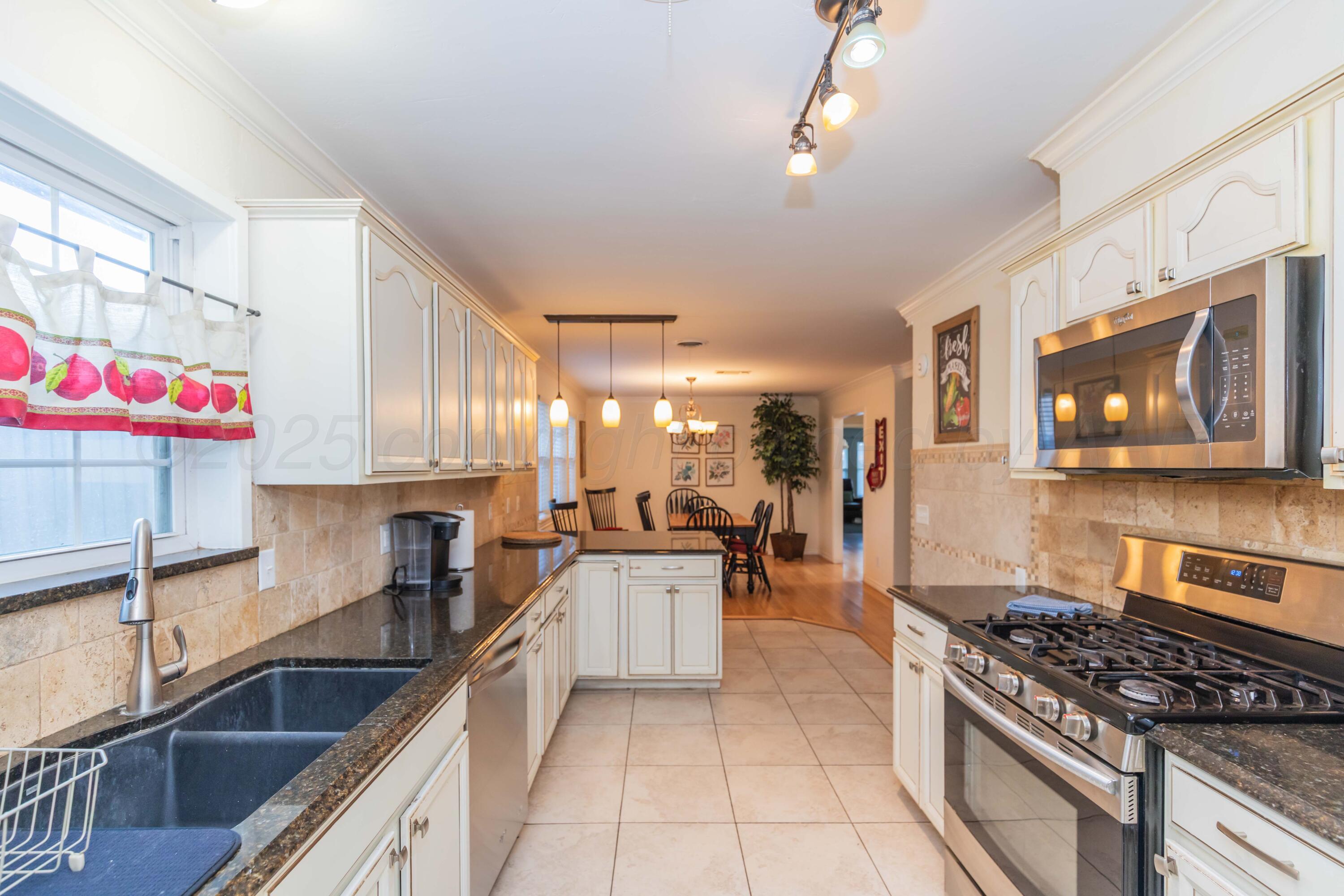 4427 Summit Circle Amarillo, TX 79109 - Photo 37 of 50 a kitchen with stainless steel appliances granite countertop a stove a sink and a microwave