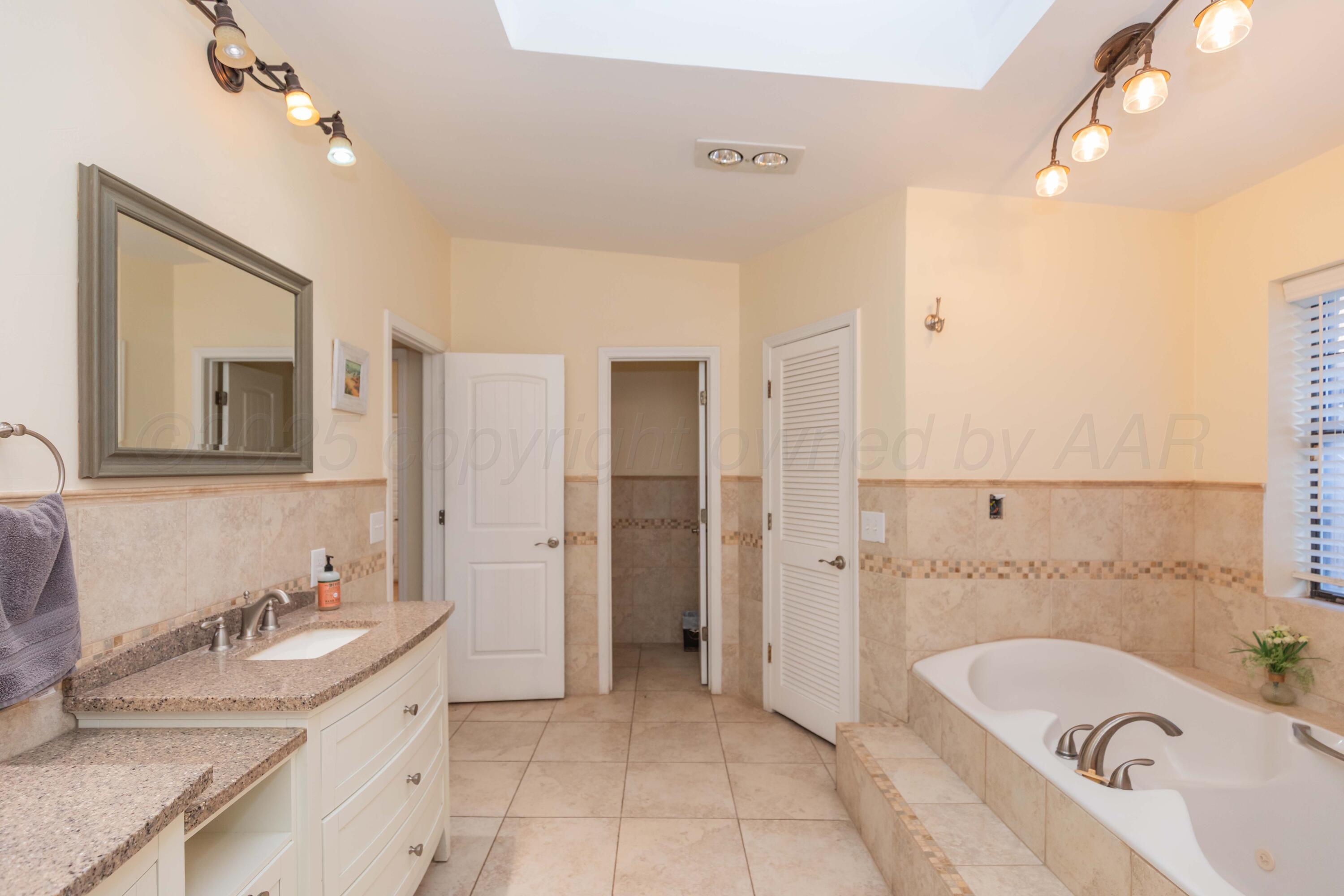 4427 Summit Circle Amarillo, TX 79109 - Photo 44 of 50 a bathroom with a granite countertop tub sink and mirror