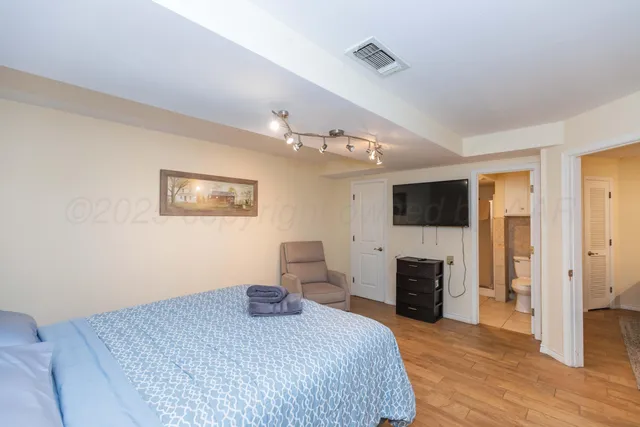 a bedroom with a bed and flat screen tv