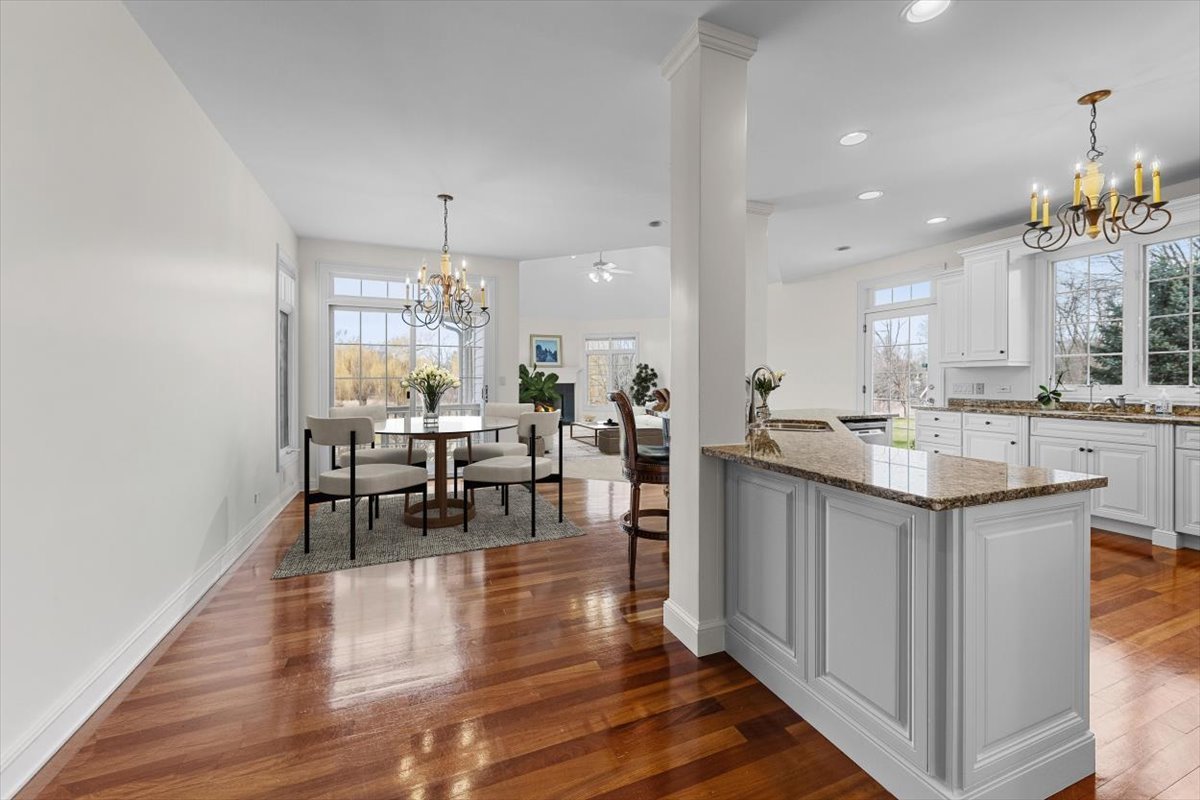 1175 Woodburn Court Inverness, IL 60067 - Photo 14 of 68 a open kitchen with stainless steel appliances granite countertop a stove top oven a dining table and chairs with wooden floor