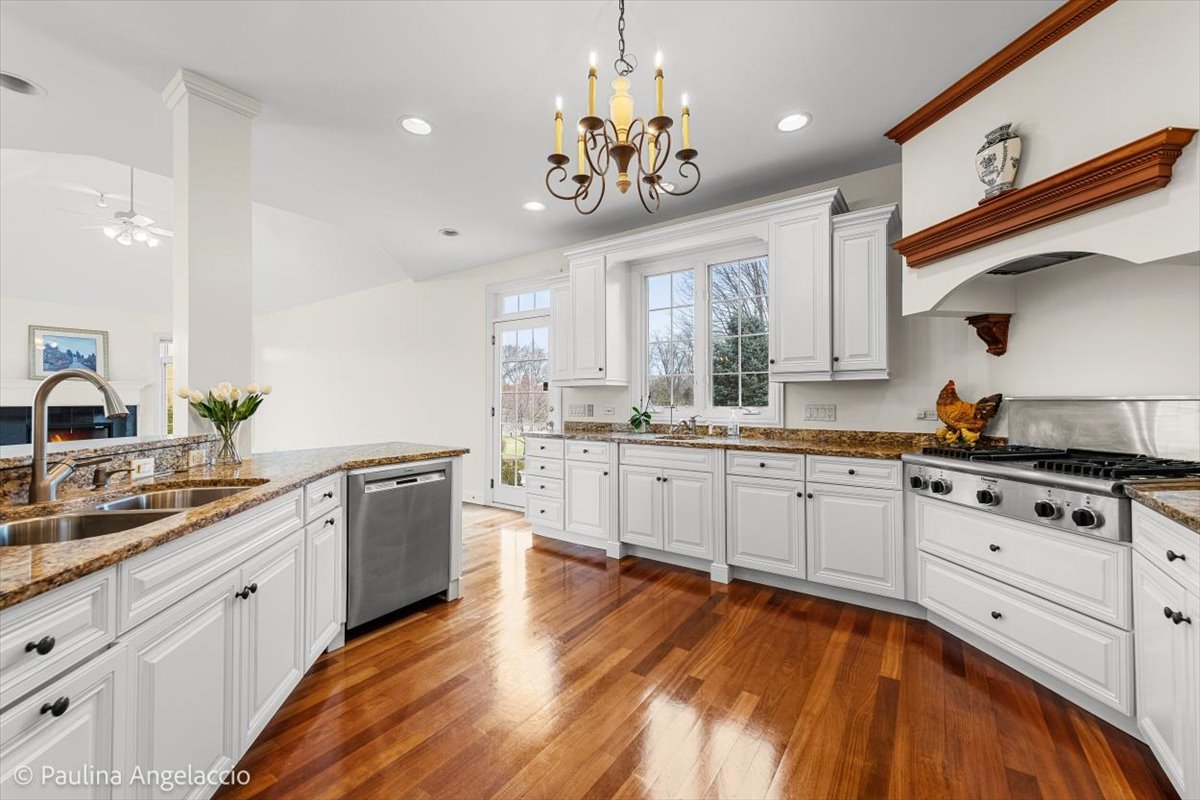 1175 Woodburn Court Inverness, IL 60067 - Photo 15 of 68 a large kitchen with stainless steel appliances granite countertop a stove a sink dishwasher and white cabinets with wooden floor