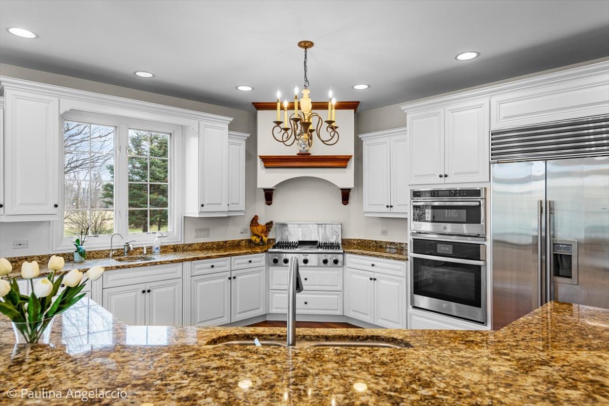1175 Woodburn Court Inverness, IL 60067 - Photo 16 of 68 a kitchen with stainless steel appliances granite countertop a sink stove and refrigerator