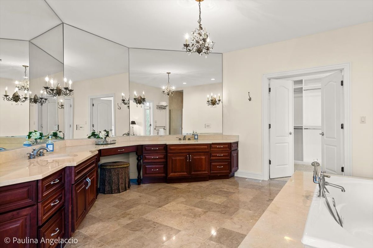 1175 Woodburn Court Inverness, IL 60067 - Photo 26 of 68 a spacious bathroom with a granite countertop double vanity sink a large mirror and a bathtub