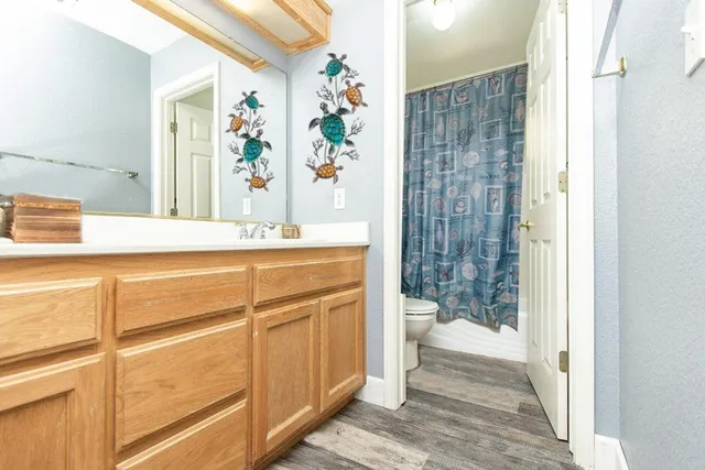 a bedroom with a bed a desk and chair with the wooden floor