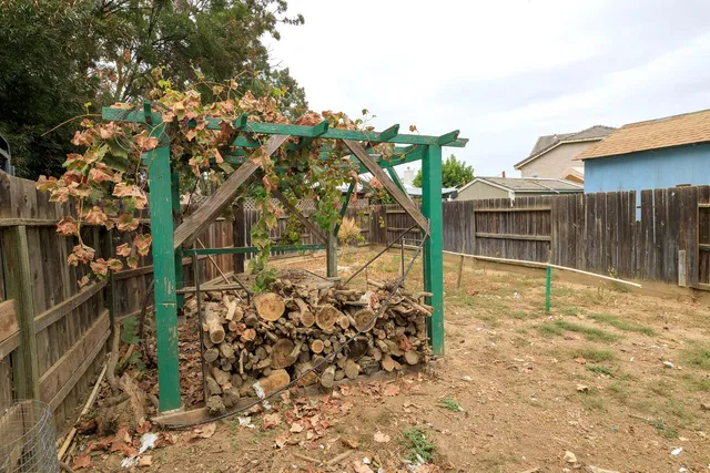 a view of a patio with a table chairs and a small yard
