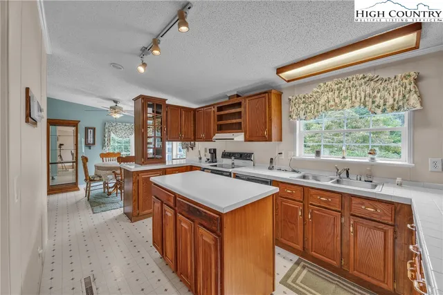 a kitchen with stainless steel appliances granite countertop sink stove top oven and cabinets