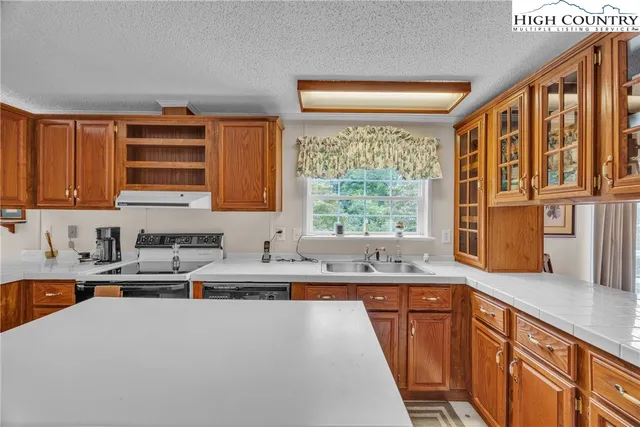 a kitchen with stainless steel appliances a sink a stove and a window